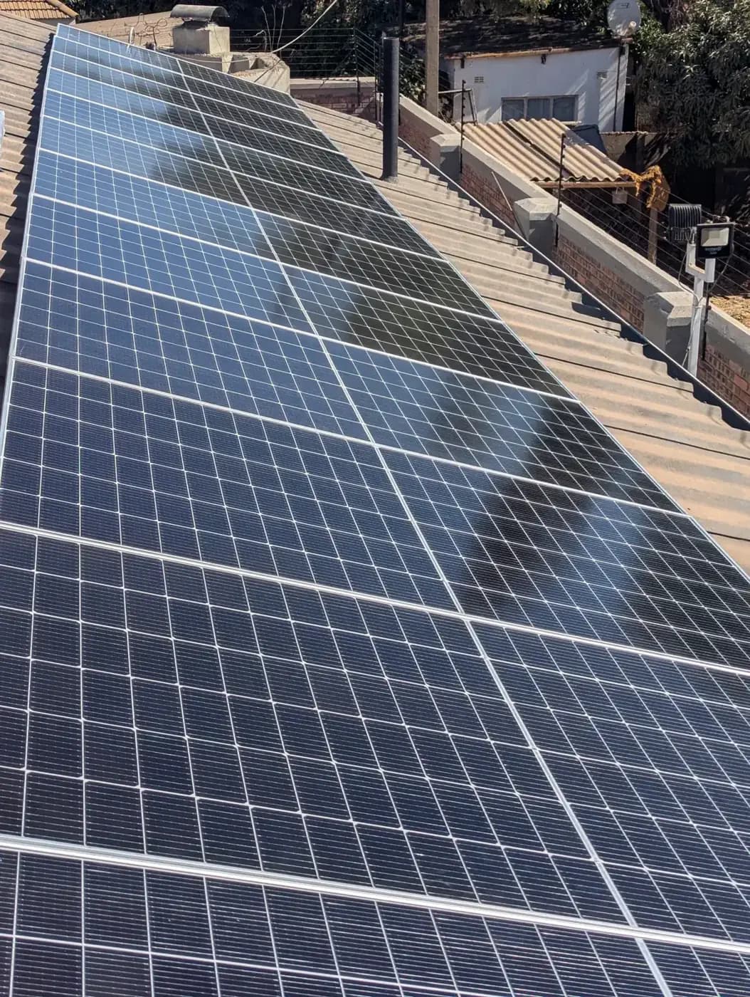 Solar: Rows of panels along a long pitched roof, set out to catch the sun all day in Kwekwe, Zimbabwe